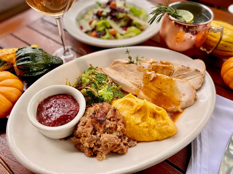 Image: A Thanksgiving meal in a room with a wall lined with beer on tap. We can get behind that.
