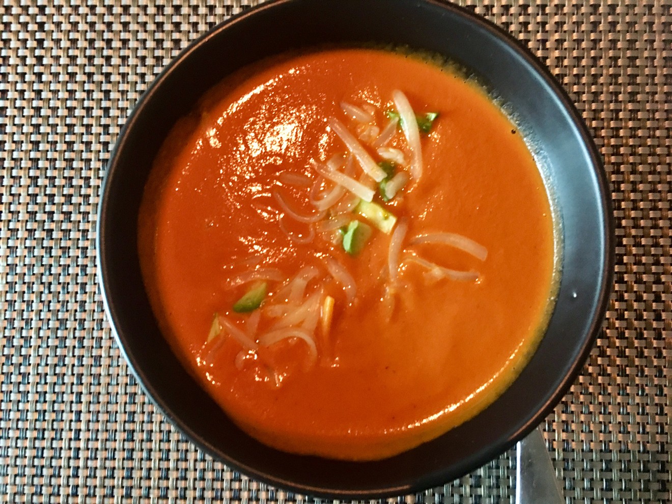 A bolt of white cheddar and avocado top the roasted tomato soup at Knife (cup for $6; bowl for $12).