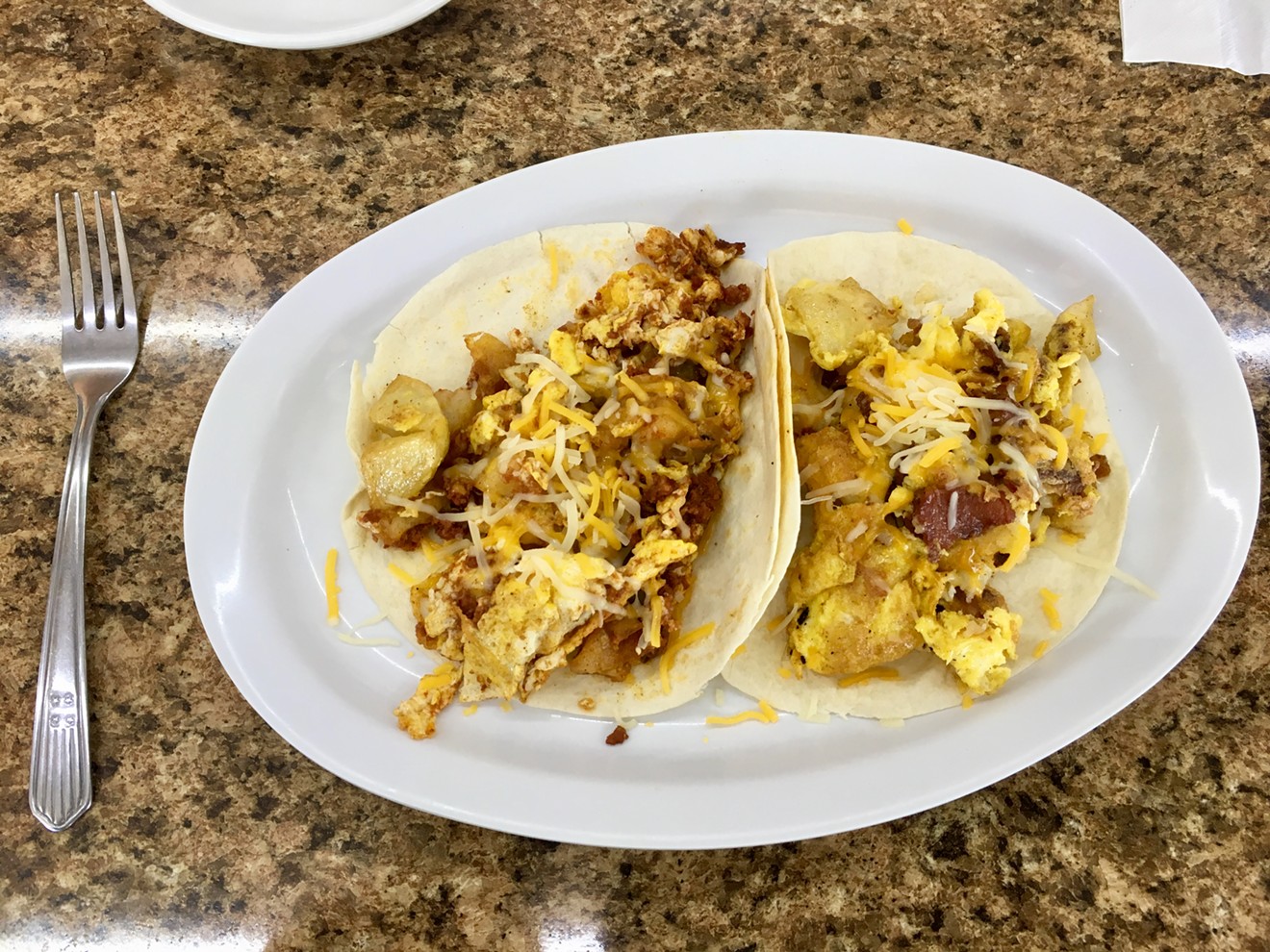 Two breakfast tacos, one with crumbled chorizo and the other with bacon, for six bucks and change.
