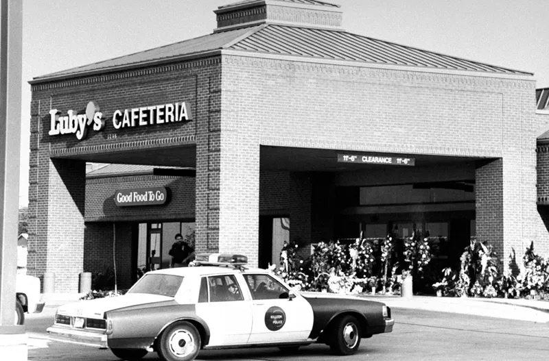 Image: A Killeen city police car parks near the front entrance to Luby's Cafeteria w. wreaths & baskets of flowers placed there by mourners for the 23 killed and 27 others wounded in a massacre by crazed gunman George Hennard who used two 9-mm semi-automatic pistols.