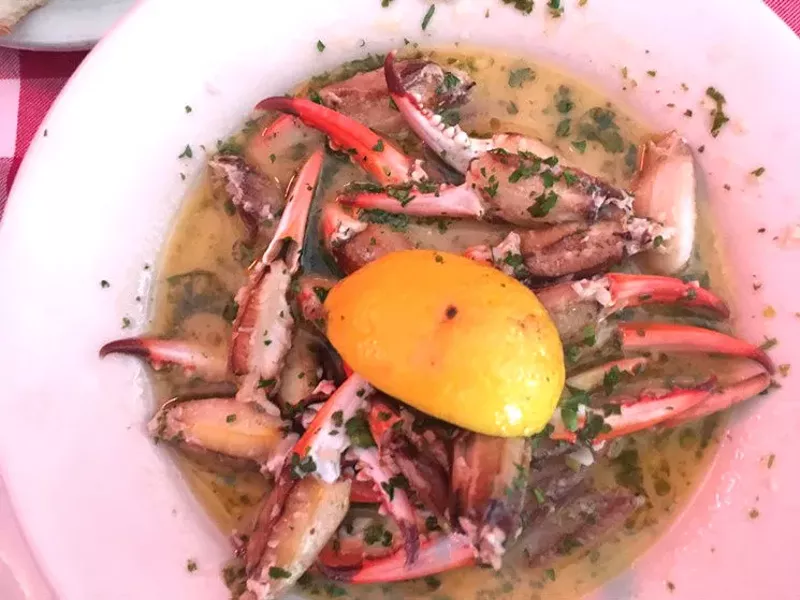 Image: Crab claws in a bath of garlic, lemon and butter, a dish nearly impossible not to love.