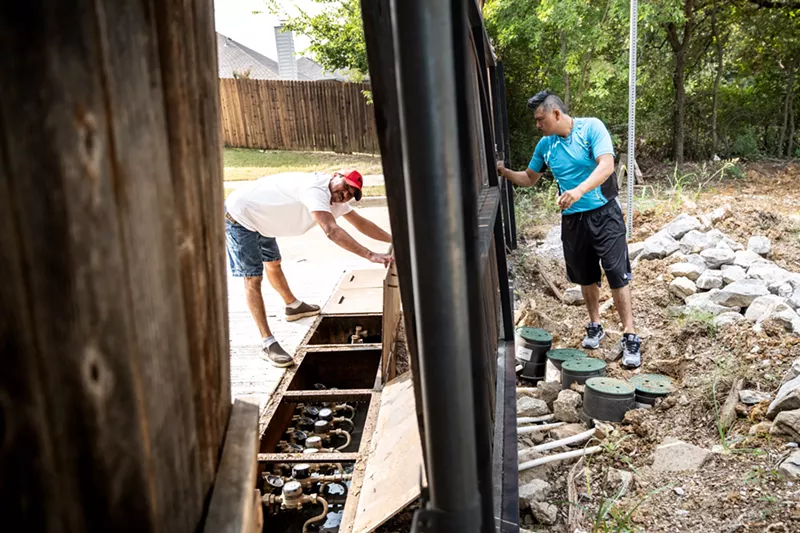 Image: The city of Denton installed water meters in the new development opposite Green Tree Estates, requiring residents to lay pipes from the meter to their homes. Alfredo (left) and Homero (right) work on the pipe system.