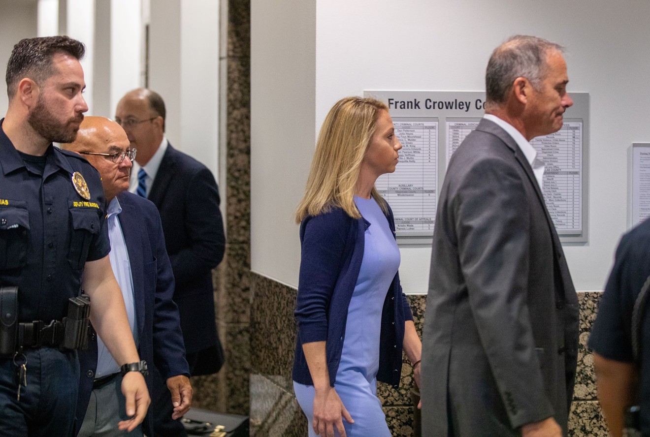 Former Dallas police officer Amber Guyger walks with her attorneys into the Frank Crowley Courts Building. Guyger faces a murder charge in connection with the killing of her upstairs neighbor Botham Jean.