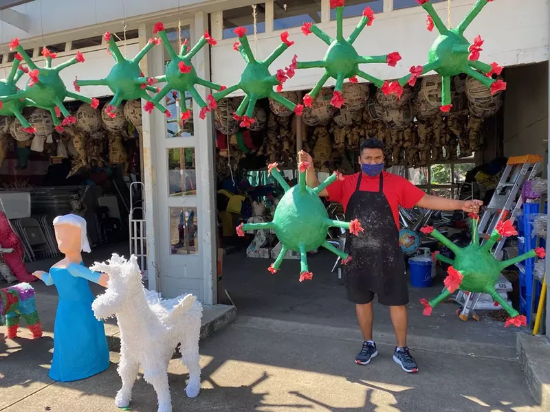 Image: Alex Segreto holding his COVID-19 piñatas, which are ready to take a good beating.