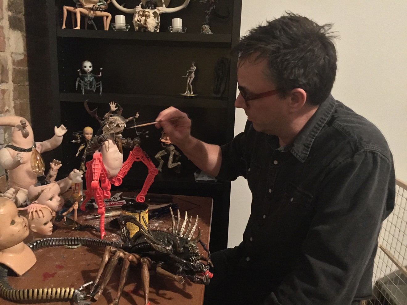 Artist and comedian David Jessup adds some stains to one of his macabre creations that he builds from discarded toy parts.
