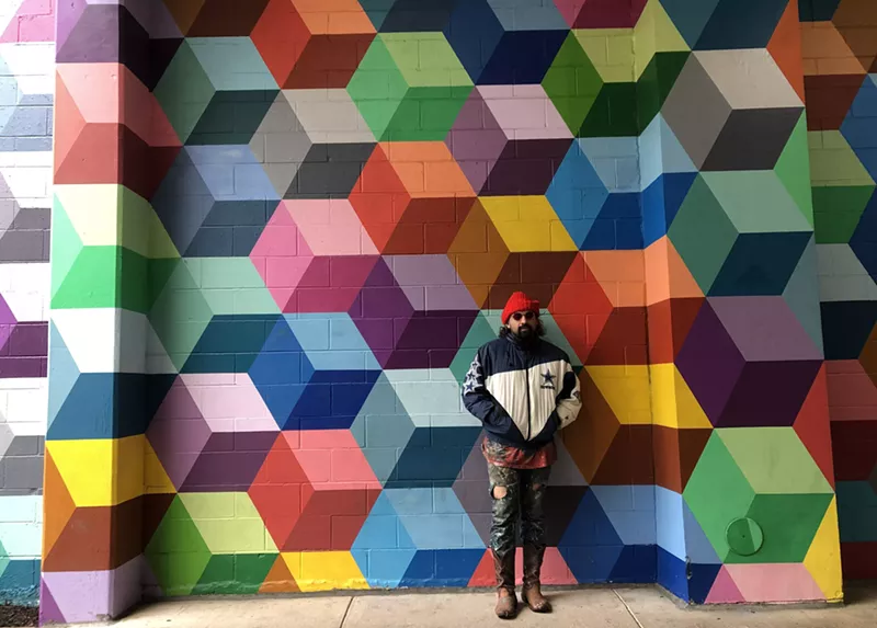 Image: Artist Ricardo Paniagua standing in front of his mural, which he says is being copied.