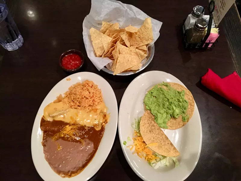 Image: The Taxco plate, with two enchiladas (one coated in queso and the other in El Fenix's chile con carne), a beef picadillo taco and a guacamole tostada for $12.49.
