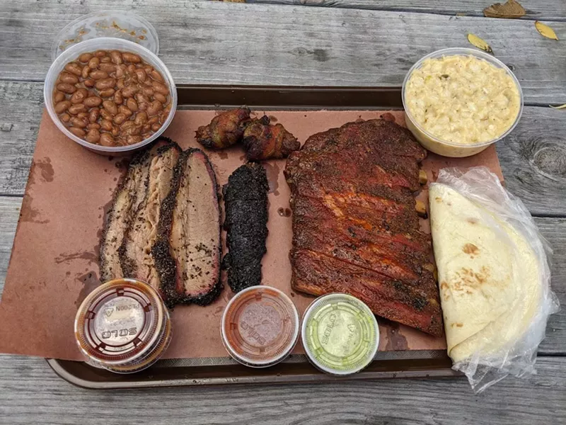 Image: A spread of Zavala's Barbecue specialties at one of its outdoor picnic tables.