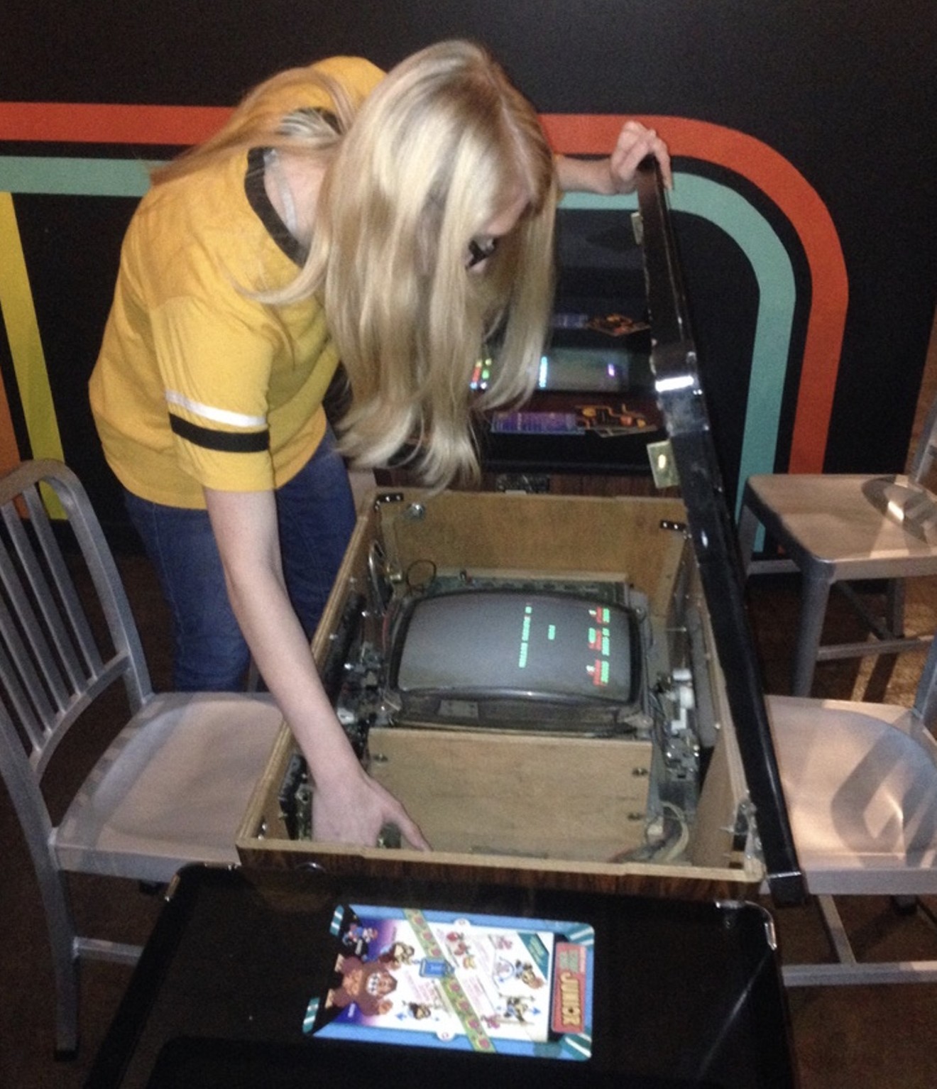 An employee of the Free Play Arcade in Richardson repairs a Tetris cocktail cabinet.
