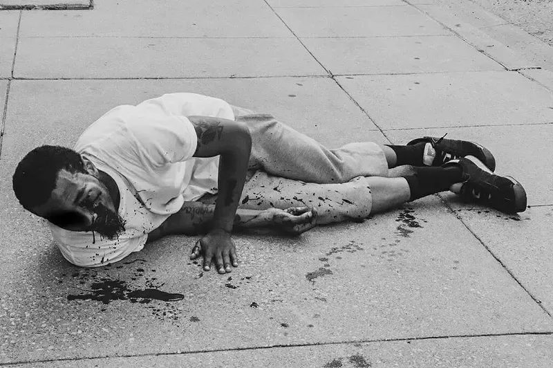 Image: Brandon Saenz lies on a sidewalk bleeding from his eye after a Dallas police officer shot him in the face with "less-than-lethal" ammunition.