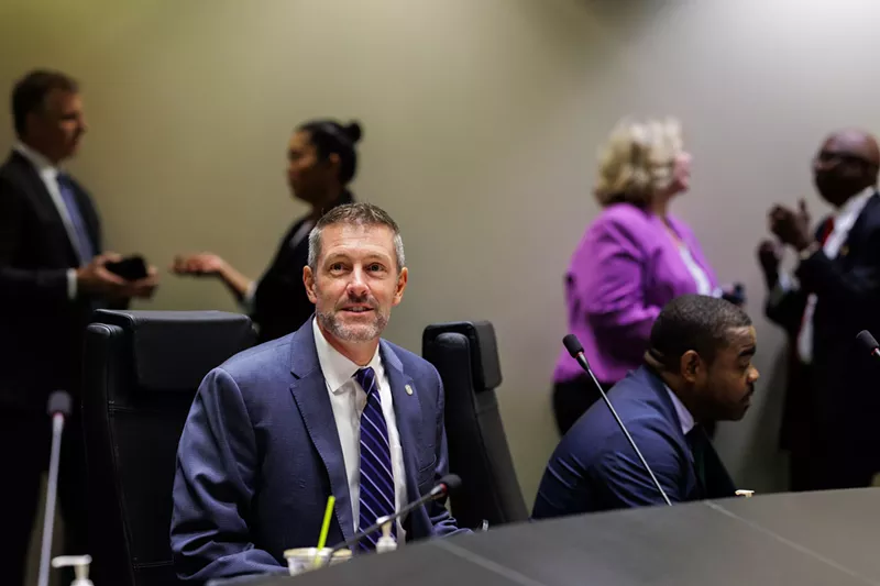 Image: man in a blue suit at a Dallas city council meeting