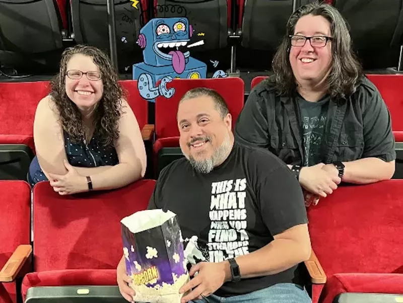 Image: (L-R) Liz Barksdale, Albie Robles and Danny Gallagher with their Mocky Horror Picture Show robot mascot illustrated by David DeGrand.