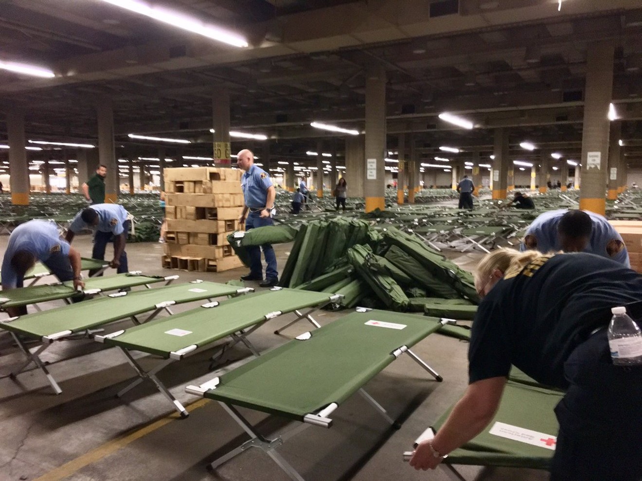 Dallas Fire and Rescue personnel set up cots in the convention center's parking garage.