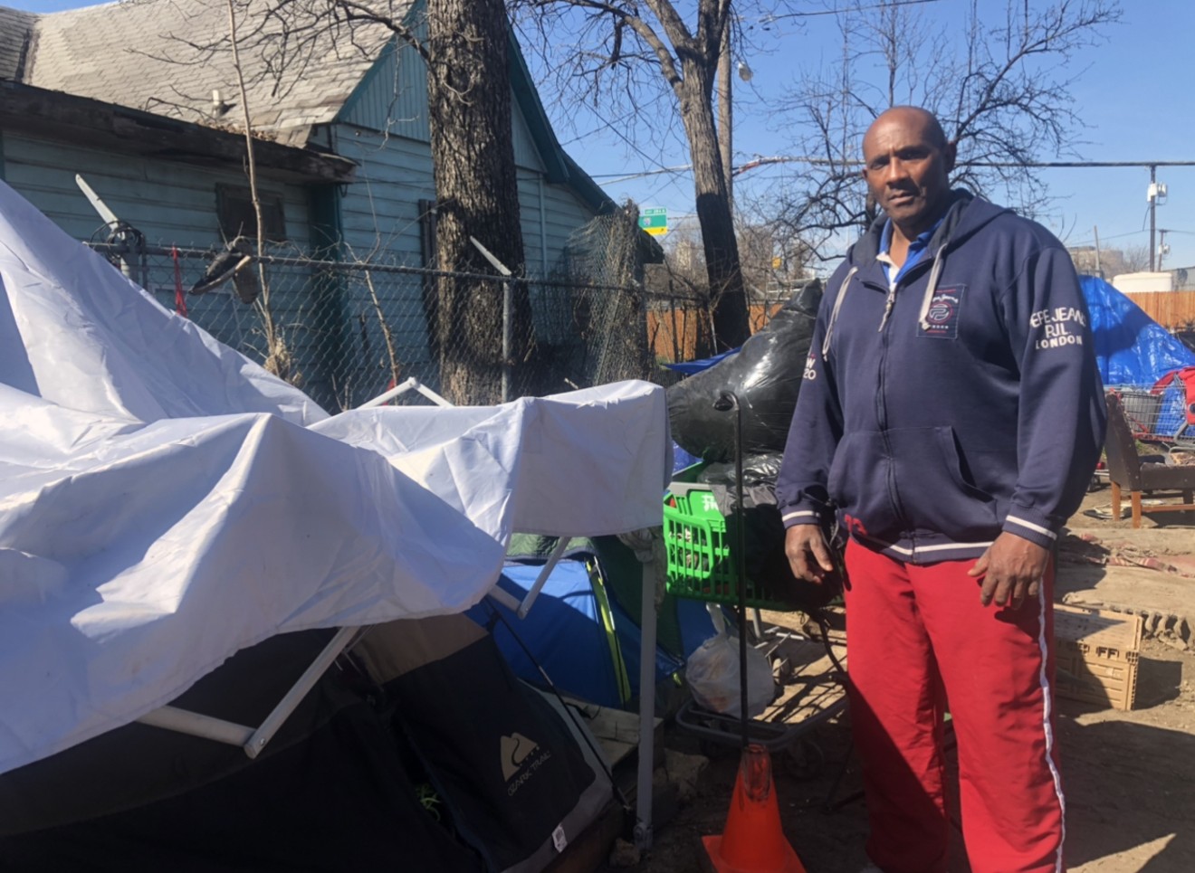 Kevin Stuart, a homeless veteran, stands near his tent at a Dallas homeless encampment in 2021.