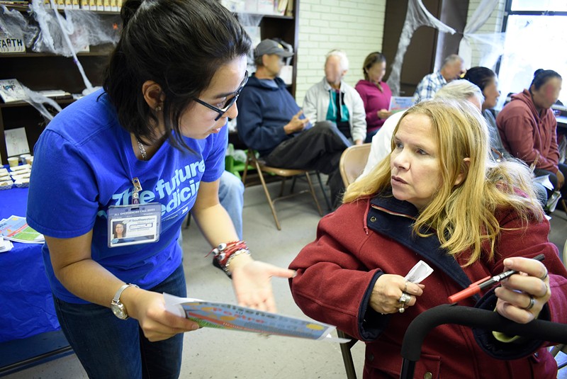 A UT Southwestern employee talks to a client at Crossroads' pantry.