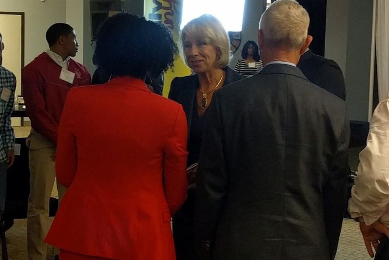 Dallas School Board trustee Bernadette Nutall, with her back to the camera, welcomes U.S. Secretary of Education Betsy DeVos.