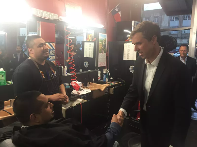 Image: Beto O'Rourke (right) shakes hands with Genaro Menchach at Bishop Barbers, owned by Marcus Santillan, on Jefferson Boulevard.