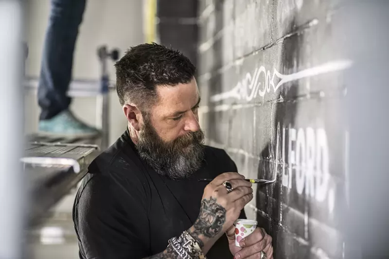 Image: Sean Starr paints letters in his large-scale piece adorning the Dallas gallery's back wall.