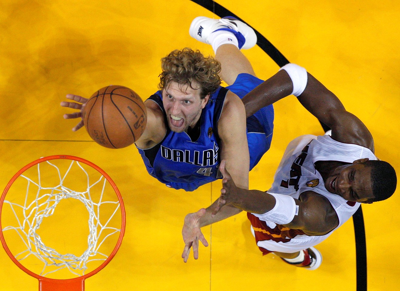Dallas Mavericks' Dirk Nowitzki  shoots past Miami Heat's Chris Bosh during the first half in Game 1 of the NBA Finals in Miami, May 31, 2011.