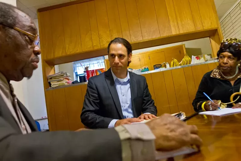 Image: HMK’s Khraish Khraish, center, talks to tenants buying one of his rental houses.