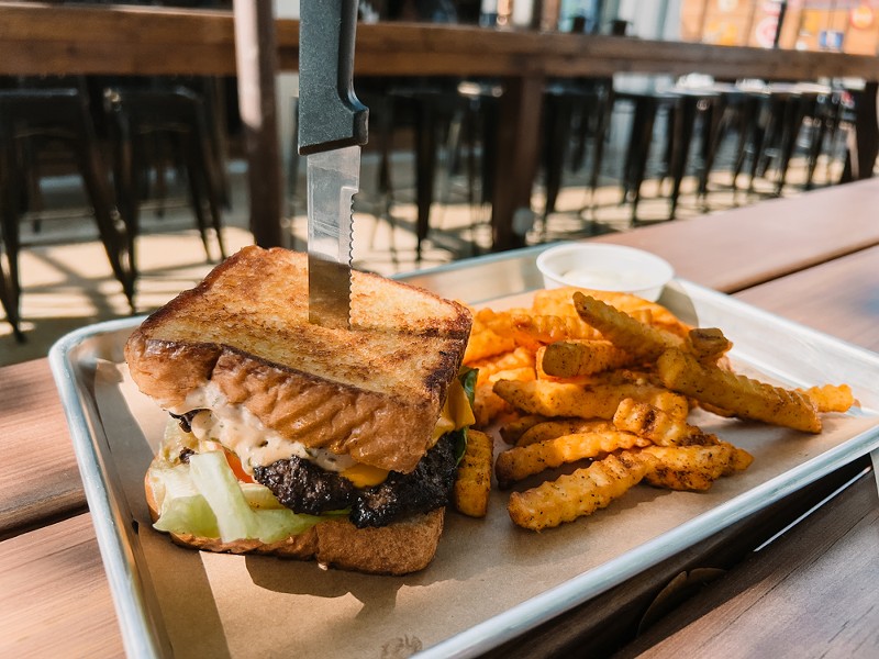 Old 75's burger and fries are packed with flavor and are a must-order during happy hour.