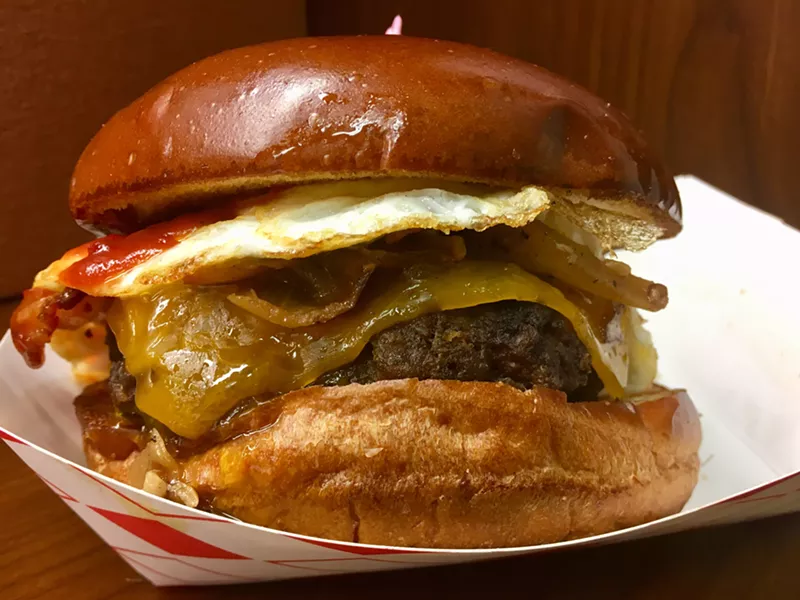 Image: The mammoth $9 hamburger at Eggstand, with bacon, cheddar, a fried egg and Chipotle ketchup.