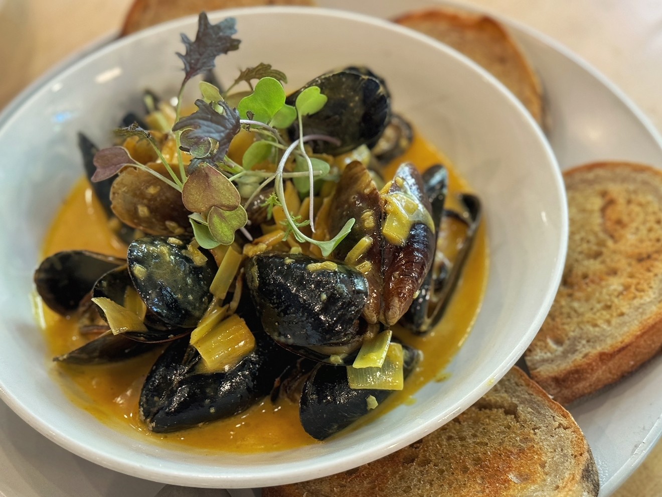 Mussels with melted leeks in a rich butter broth with turmeric at Sachet is typical of the dishes often served at a Feast of Seven Fishes Christmas Eve meal.