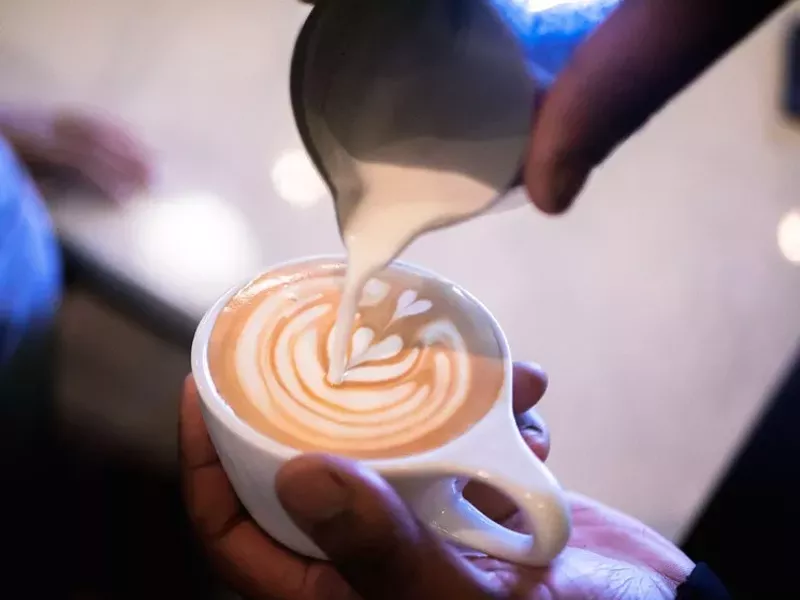 Image: Dee Traylor pours a cappuccino at newly rebranded Rosalind Coffee in Garland.