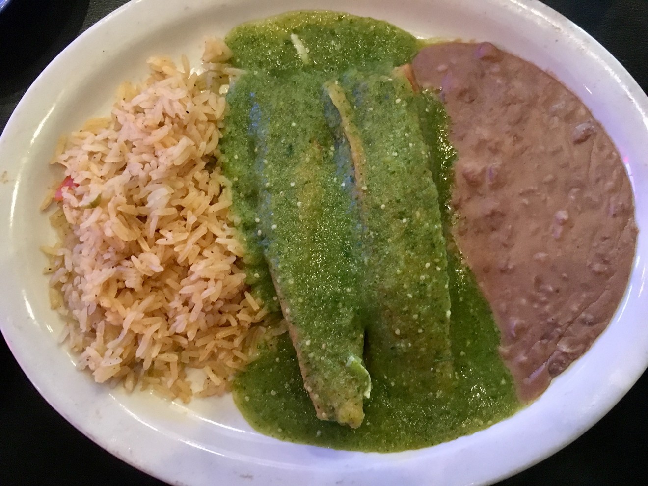 The tamales, made from a longtime recipe from Pedro Rojas' family, are served under electric-green salsa.