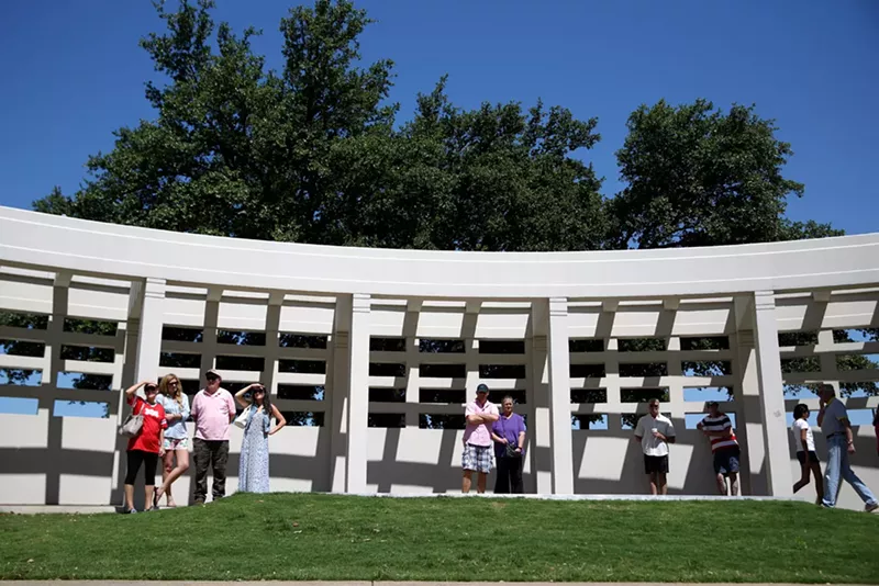 Image: Tourists atop the grassy knoll, the most popular site for geocaching.