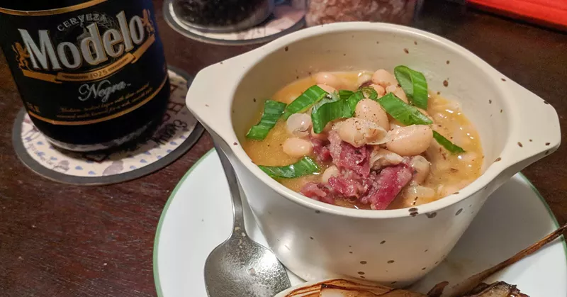 Image: A cup of homemade beans with Cattleack Barbeque's bright red pastrami beef ribs