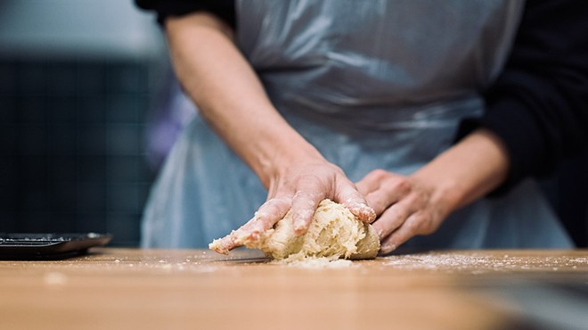 a person rolling dough on a counter