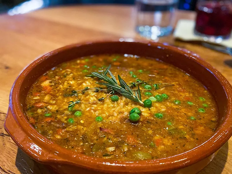 Image: Braised brisket caldoso: Valencia style rice, beef, sofrito, piquillo confit, peas and chickpeas.