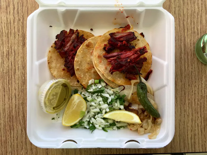 Image: Three tacos with butter-grilled tortillas and tender pork sliced off the trompo.