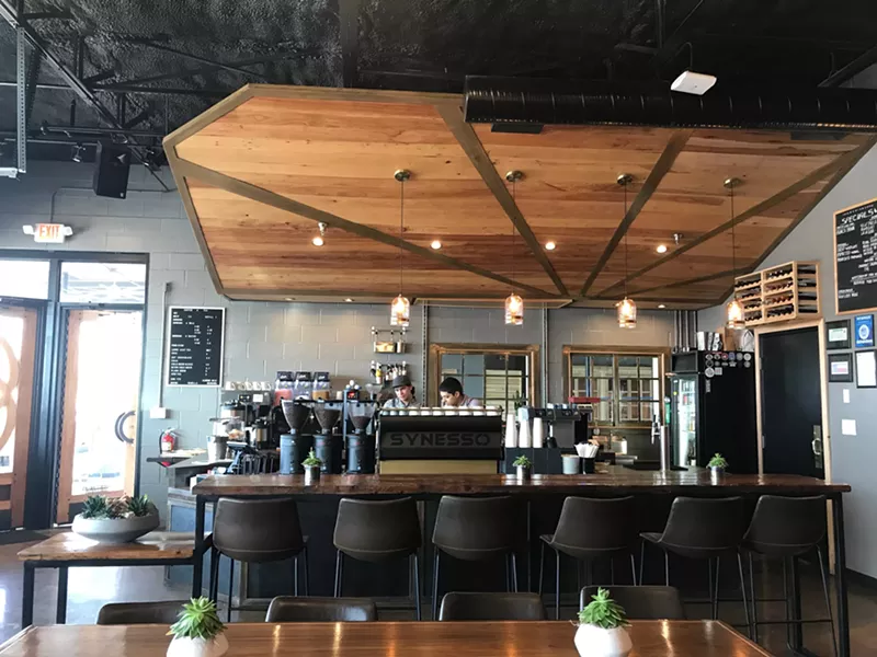 Image: The coffee bar at Communion Neighborhood Cooperative in Richardson, where a former auto garage finds new life as a coffee shop, restaurant and coworking space.