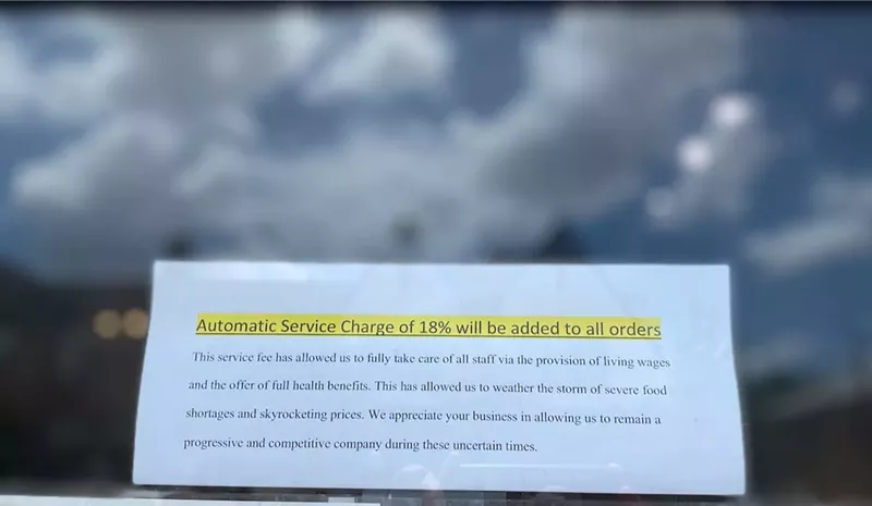 Image: A sign outside Old Hag's explaines the restaurant's 18% mandatory service fee.