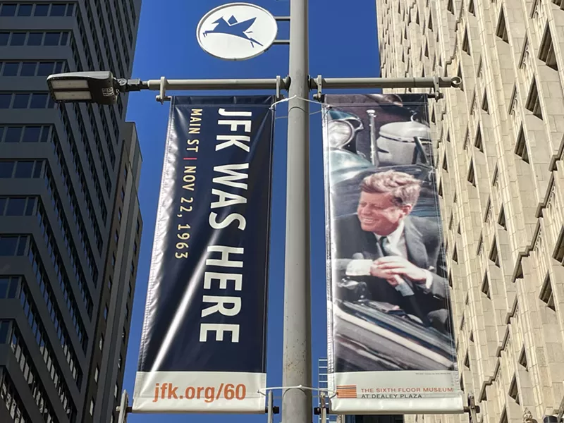 Image: Banners commemorating the 60th anniversary of President John F. Kennedy's assassination have some Dallas residents scratching their heads.