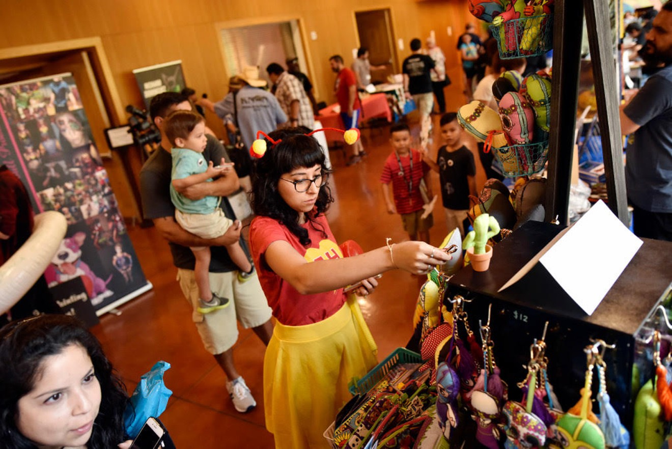 A guest of the 2019 Texas Latino Comic Con cosplaying as the television superhero El Chapulín Colorado peruses some merch.