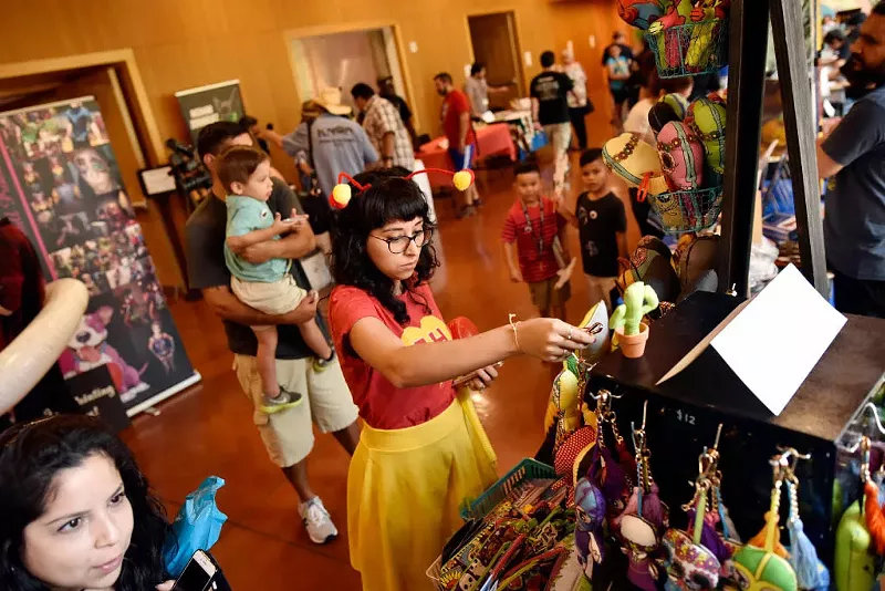 Image: A guest of the 2019 Texas Latino Comic Con cosplaying as the television superhero El Chapulín Colorado peruses some merch.