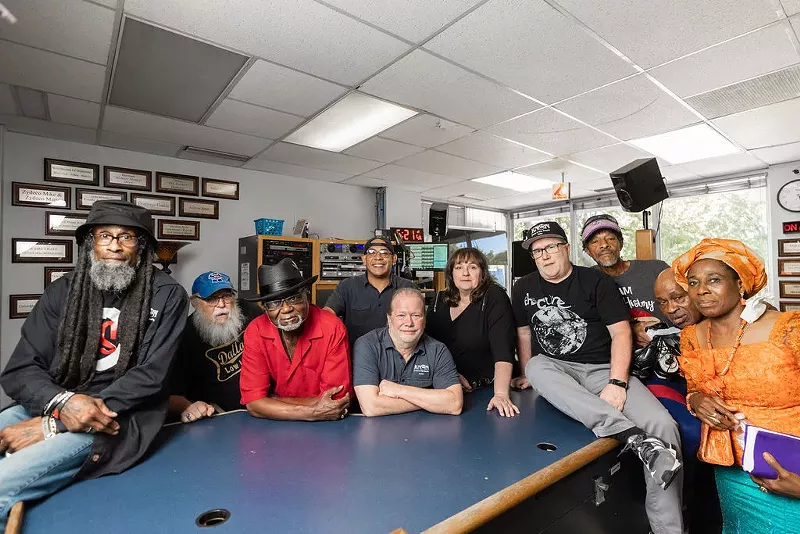 Image: KNON staff and radio personalities, from left: DJ EZ Eddie D, Charlie Don’t Park, Greg A. Smith, DJ Kane, general manager Dave Chaos (center), Blue Lisa, music director Christian Lee, Red Ghost, Ima Uwagbai and Helen Abara.