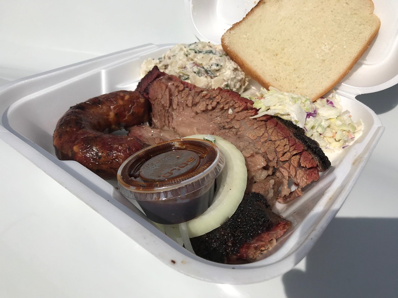 We care not that we're eating from a Styrofoam tray — this brisket and sausage are absolutely killer.