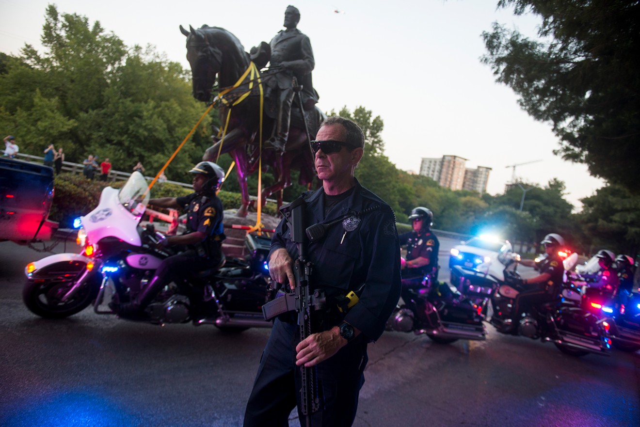Police escort the freshly removed statue of Robert E. Lee.