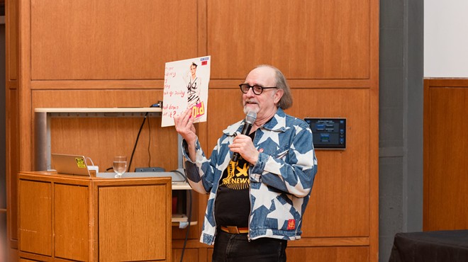 The legendary Malcolm Garrett, wearing a Vivienne Westwood design, speaking at the punk exhibition Torn Apart , currently on display in Dallas.