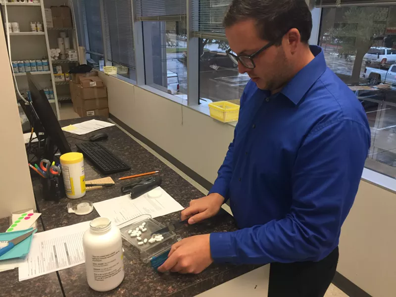 Image: Volunteer pharmacist Justin Spence prepares a bottle of prescription pills for one of the clients of the St. Vincent de Paul free pharmacy that opened in September.