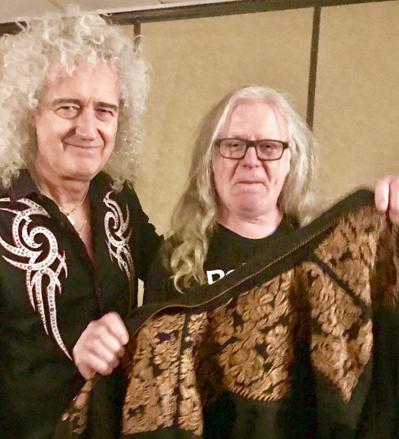 Bucks Burnett presents Queen guitarist Brian May with the shirt off his back.