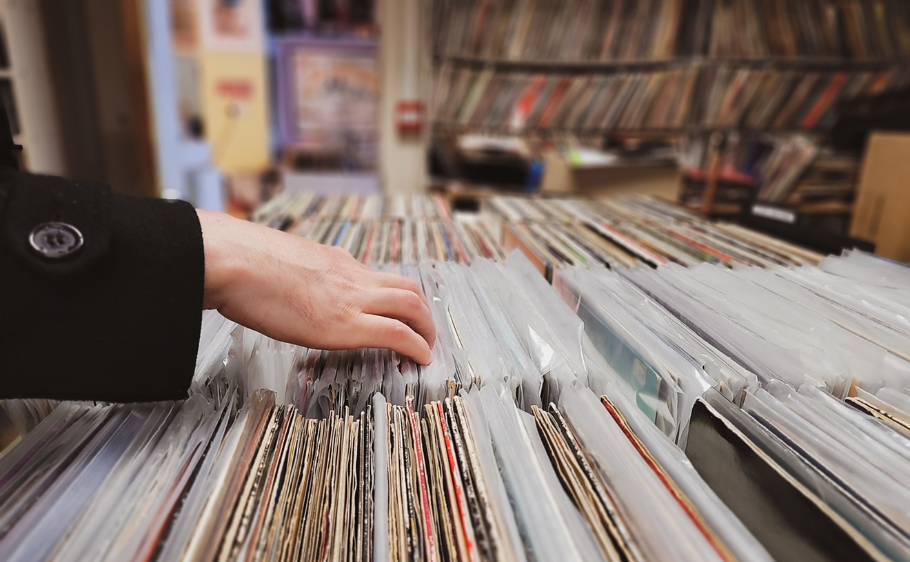 Woman flipping through vinyl records on sale.
