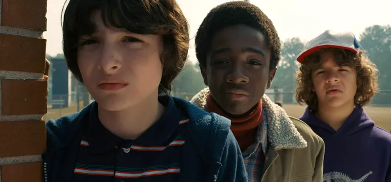 Image: Finn Wolfhard, Caleb McLaughlin and Gaten Matarazzo, looking at something totally '80s and probably moving wetly.