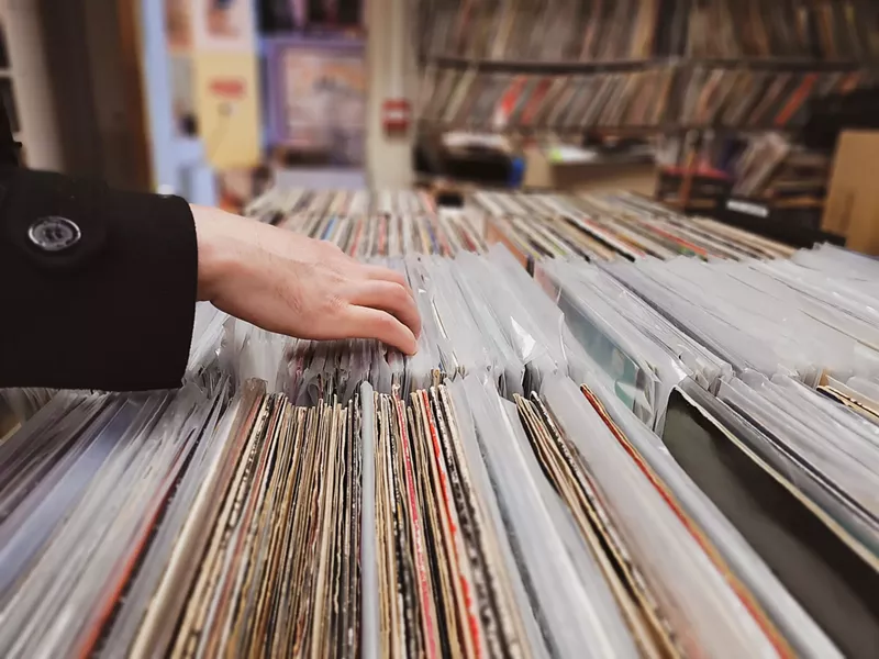 Image: Woman flipping through vinyl records on sale.