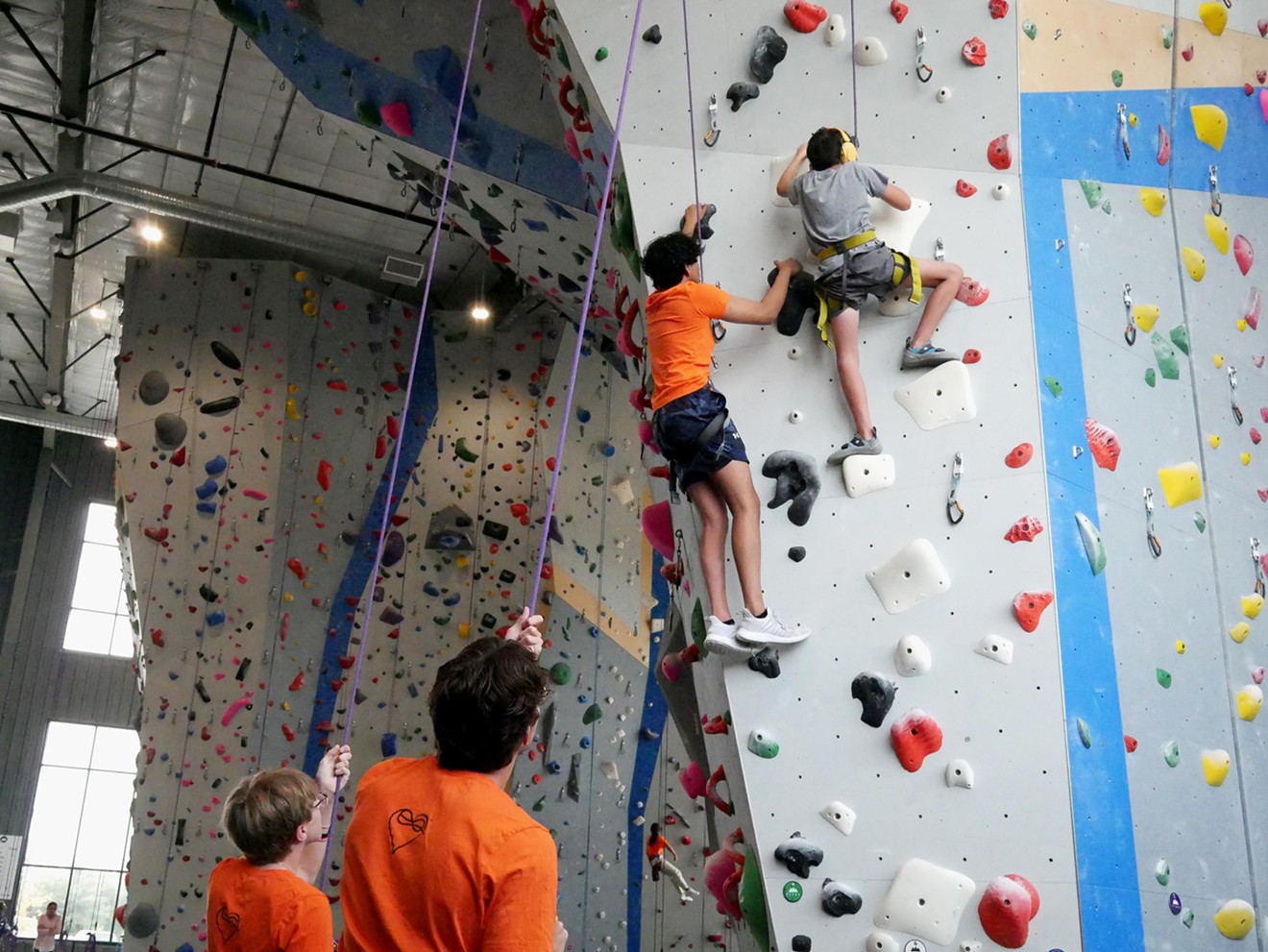 Jacob Shaffstall, 10, climbs the white route with volunteers' help at Movement Gym in Grapevine.