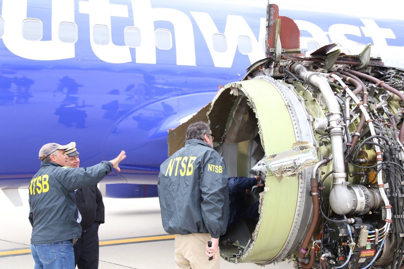 National Transportation Safety Board investigators examine the failed Southwest jet engine Tuesday night.